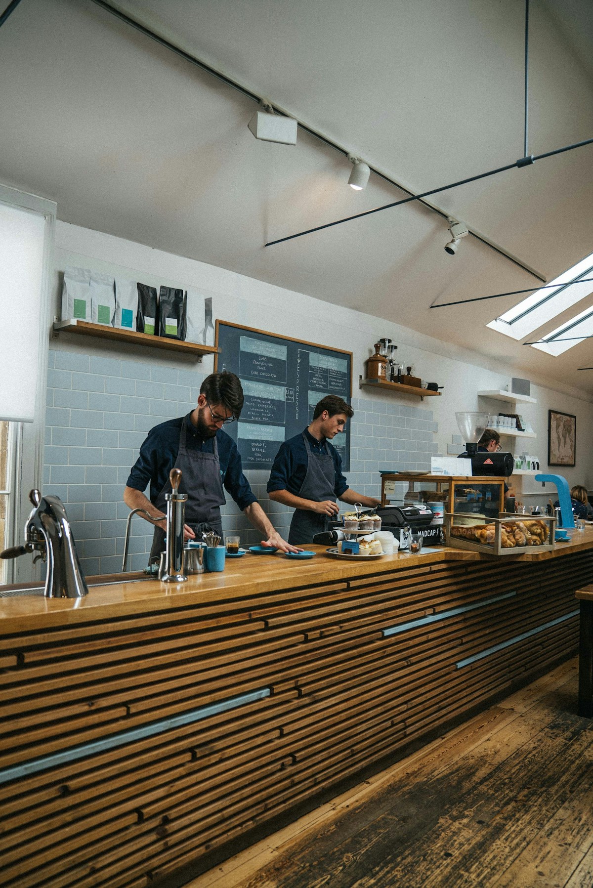 Two café team members preparing service behind a counter
